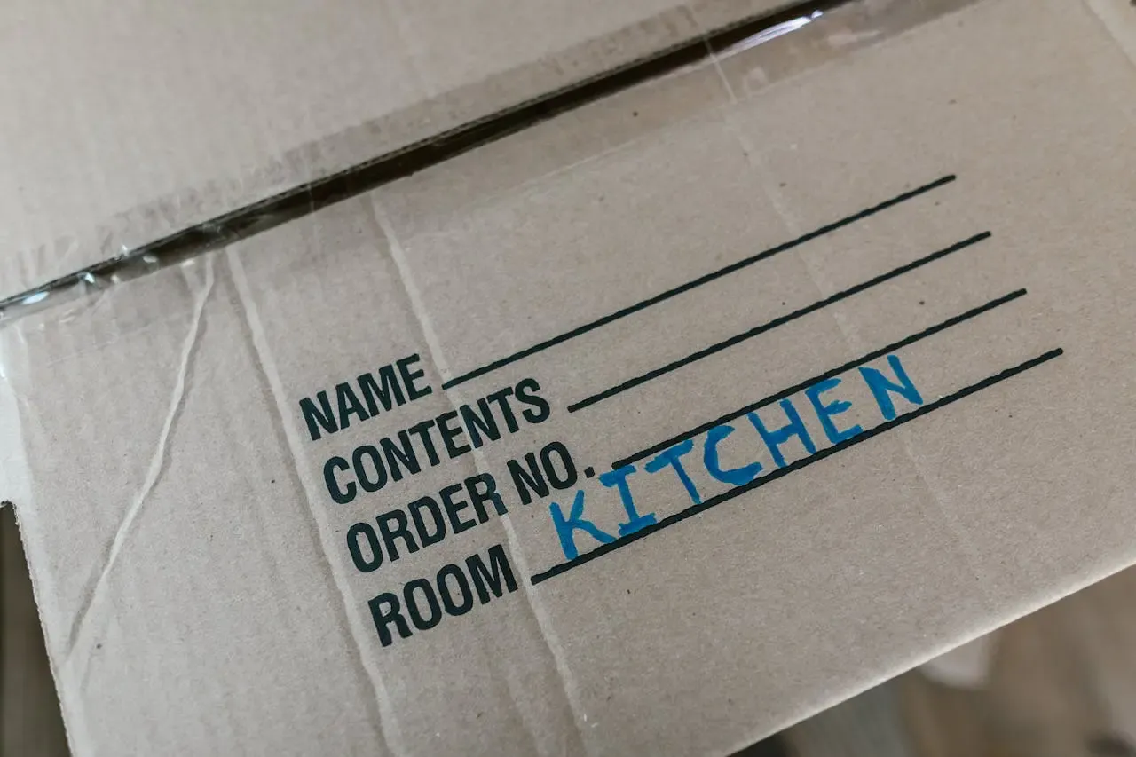 Moving boxed labelled 'Kitchen' indicating it's time for end of lease carpet cleaning that will impress your rental agent at inspection